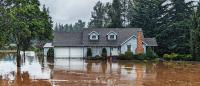 A photo of a house in the middle of brown water